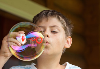 Boy blowing soap bubble