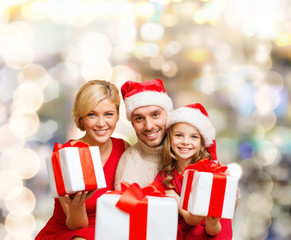 Fototapeta na wymiar happy family in santa helper hats with gift boxes