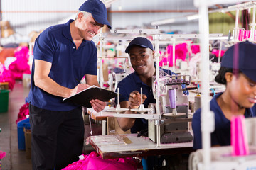 senior supervisor taking score from machinist