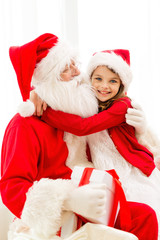 smiling girl with santa claus and gift at home
