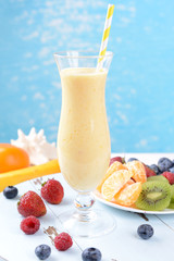 Delicious berry cocktail on table on water background