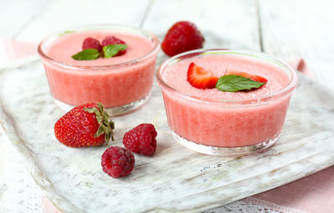 Delicious berry mousse in bowls on table close-up