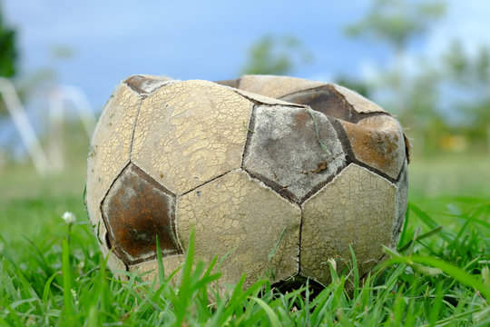 old deflated soccer ball, old deflated football on the groud