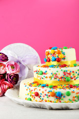 Beautiful tasty birthday cake and gifts on color background