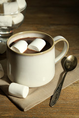 Hot chocolate with marshmallows in mug, on wooden background