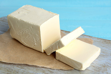 Fresh butter on cutting board, on color wooden background