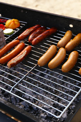 Sausages and vegetables on barbecue grill, close-up