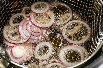 Onion in deep fryer, closeup