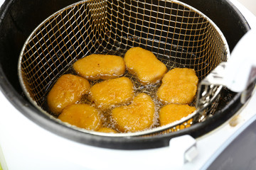 Cutlets in deep fryer, closeup