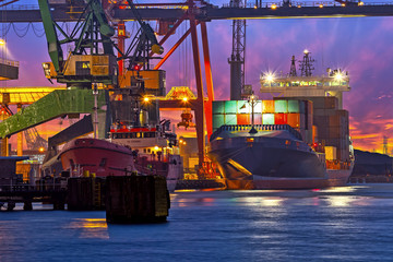 The unloading of a container ship at a large harbor terminal.
