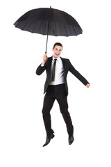 Businessman jumping with an umbrella