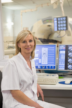 Female doctor smiling in medical MRI scan monitor room