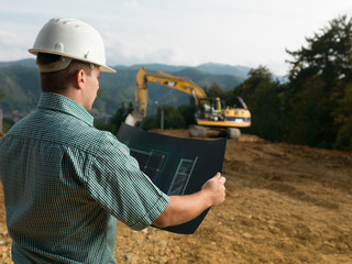 male engineer reading blueprint