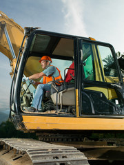male worker operating excavator © Daco