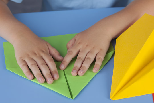 Child making a paper plane