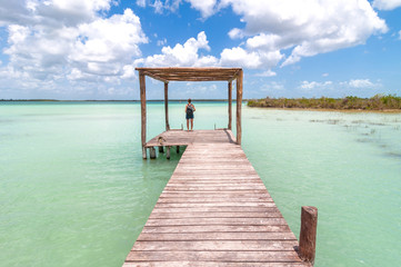 pier and woman in Bacalar lagoon, Mexico