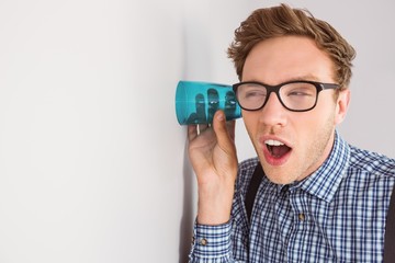 Geeky businessman eavesdropping with cup