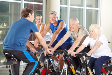 Trainer mit Gruppe Senioren beim Spinning