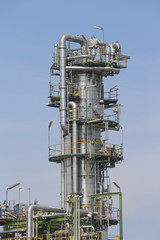 Fototapeta na wymiar Vertical refining tower with blue sky