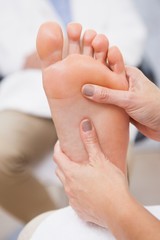 Pedicurist massaging customers foot