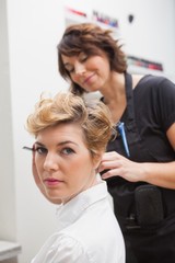 Hairdresser styling customers hair