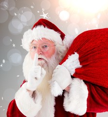 Composite image of santa claus carrying sack