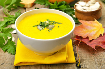 Pumpkin cream soup on wooden table
