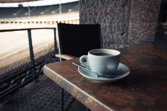 Cup of coffee on table in stadium