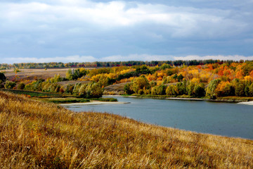Bay of sea ​​hills on background of autumn forest and gray sky