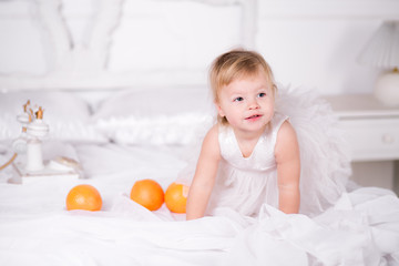 girl in a beautiful dress on the bed with oranges