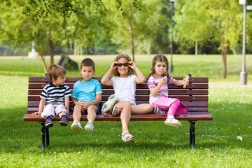 Playful group of children sitting on a bench in nature