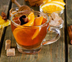 Christmas tea with orange, honey and spices on a  wooden table