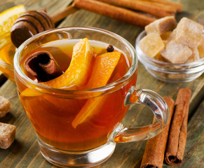 Christmas tea with orange, honey and spices on wooden background