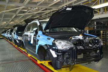 Cars stand on the conveyor line of assembly shop. Automobile pro