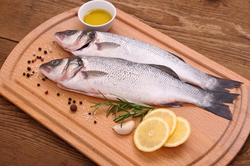 Two fresh sea bass fish on cutting board