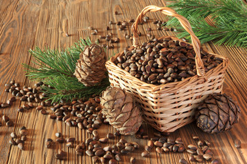 Fototapeta premium Cedar nuts in a wicker basket on a wooden table