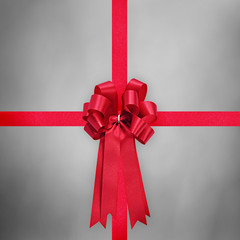 Red satin ribbon with bow on gray background