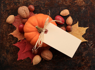 Blank cream tag on top of maple leaves, nuts and pumpkin - 71228028