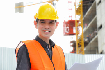 Asian engineer or foreman in front of construction site