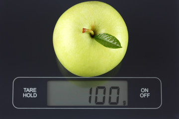 Green apple on kitchen scale
