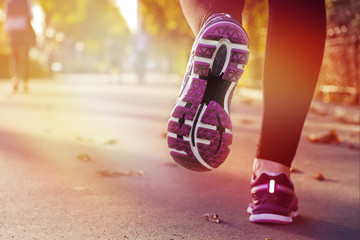 Fitness Girl running at sunset in city center