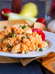 risotto with chicken and vegetables on a round plate, closeup