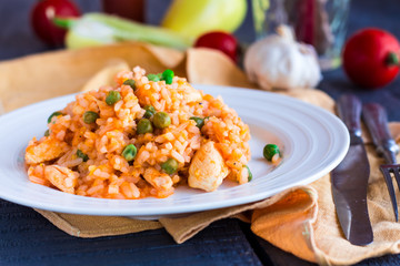 risotto with chicken and vegetables on a plate with cutlery