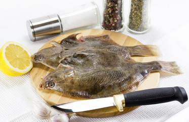 raw fish on a cutting board and knife