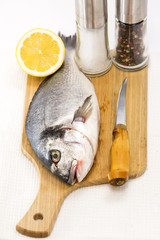 raw fish on a cutting board and knife