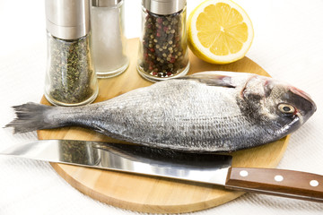 raw fish on a cutting board and knife