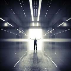Fototapeta na wymiar Abstract dark interior with lights, glowing door and man silhoue