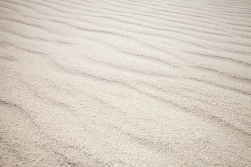 Fototapeta na wymiar White sand with waves pattern. Background texture