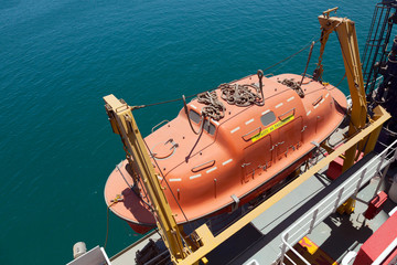 Red rescue boat hanging on the passenger ship