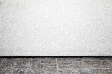 White interior background with rough stucco wall and tiling floo
